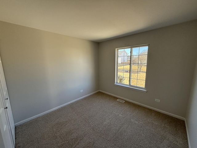 unfurnished room featuring carpet floors, visible vents, and baseboards