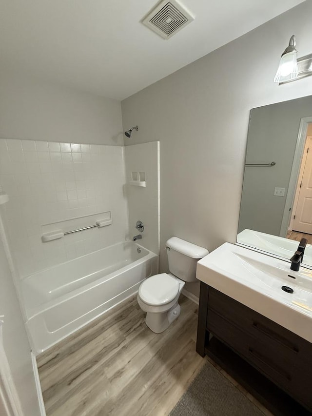 bathroom with visible vents, toilet, wood finished floors, tub / shower combination, and vanity