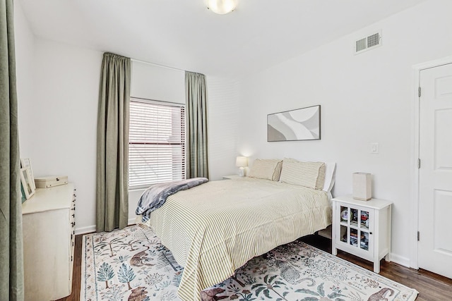 bedroom featuring visible vents, baseboards, and wood finished floors