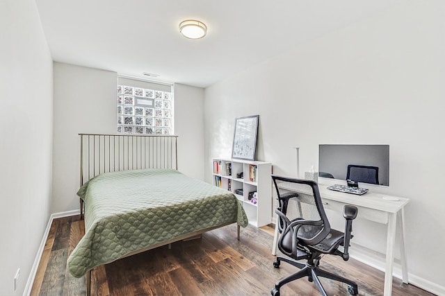 bedroom featuring baseboards, visible vents, and wood finished floors