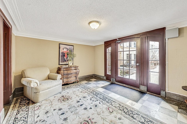 foyer with crown molding, a textured ceiling, baseboards, and tile patterned floors