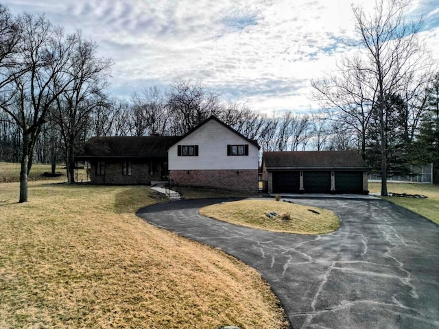 view of front of property featuring a front lawn and a detached garage