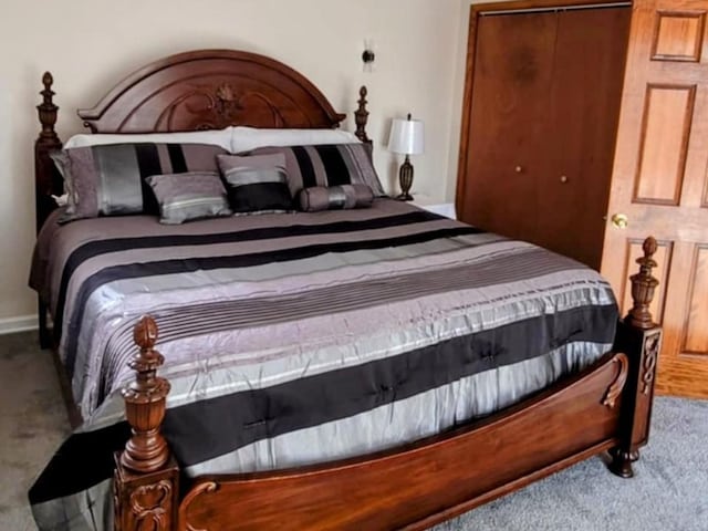 carpeted bedroom featuring a closet and baseboards