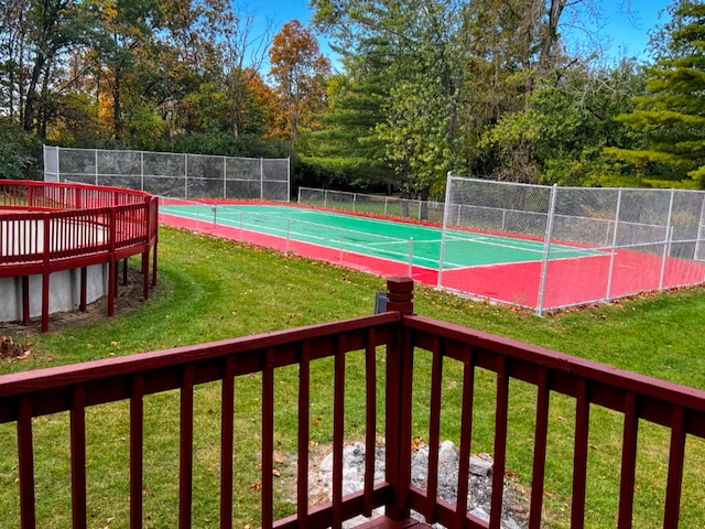 view of sport court featuring a lawn and fence