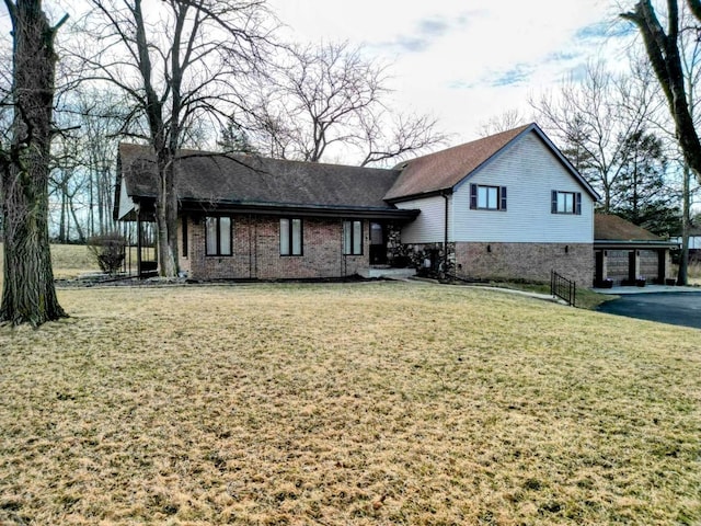 rear view of house featuring brick siding and a yard