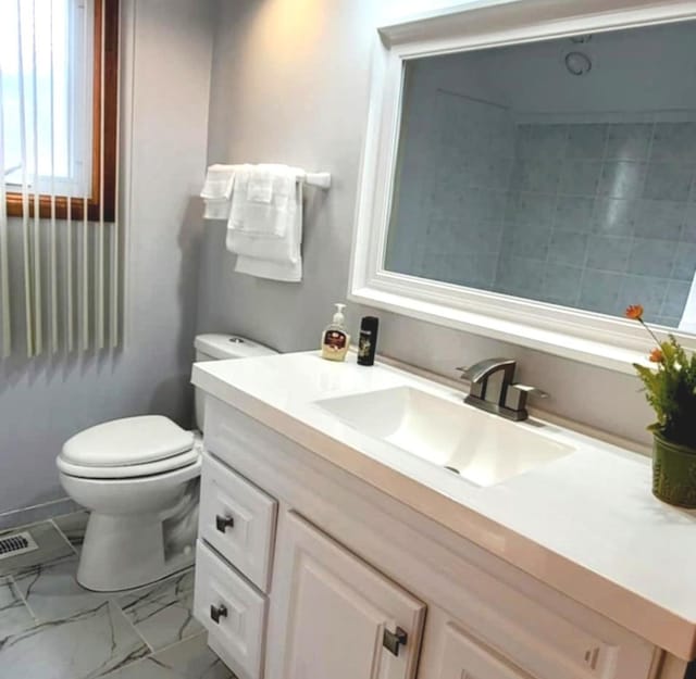 bathroom featuring visible vents, marble finish floor, vanity, and toilet