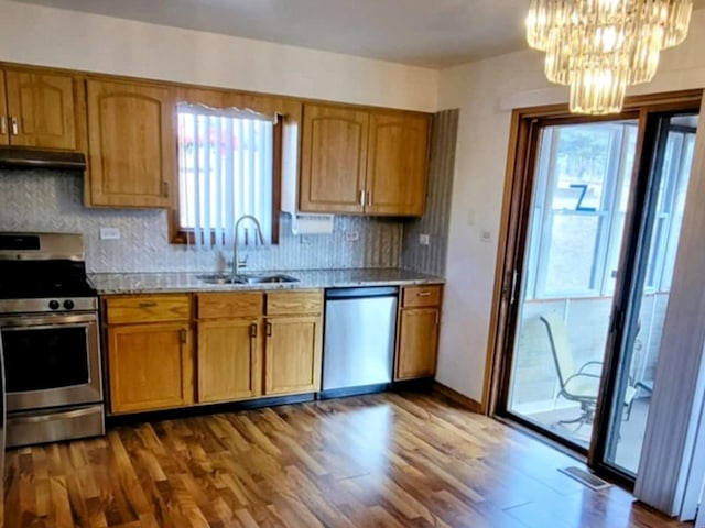 kitchen with stainless steel appliances, light countertops, a sink, plenty of natural light, and under cabinet range hood