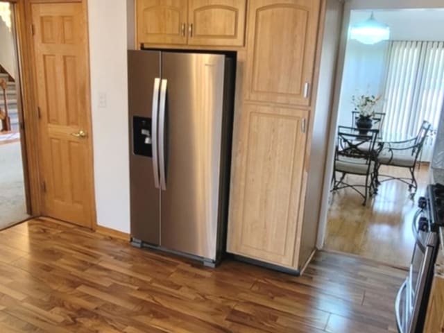 kitchen featuring stainless steel appliances, dark wood-style flooring, and light brown cabinets