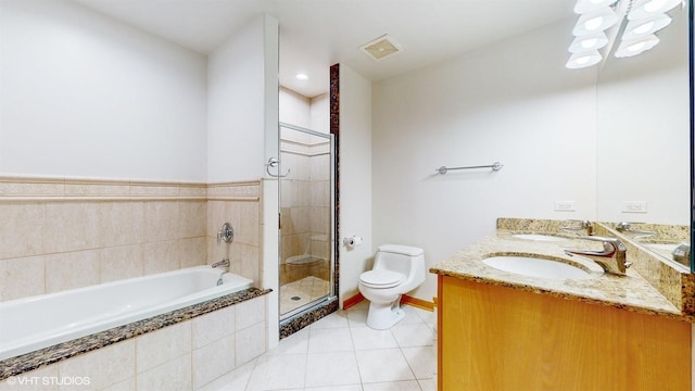 bathroom with a stall shower, a sink, toilet, and tile patterned floors