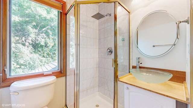 full bath with a stall shower, vanity, and toilet