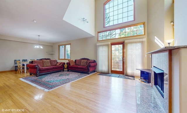 living room with a fireplace, a chandelier, and wood finished floors