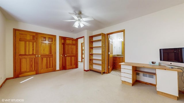 office featuring light carpet, visible vents, baseboards, and a ceiling fan