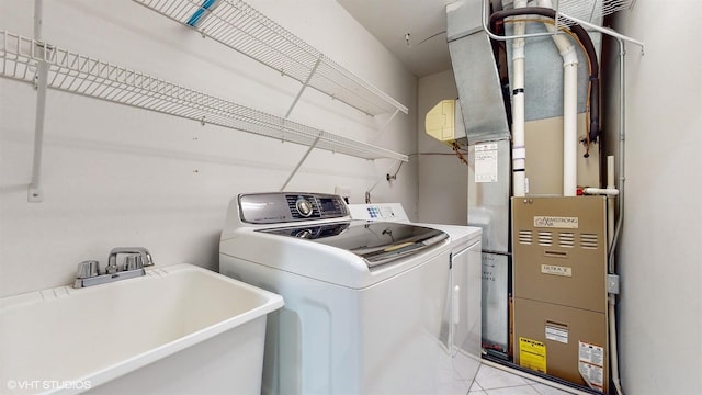 laundry area with heating unit, laundry area, washer and dryer, and a sink