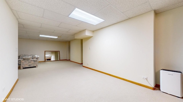 interior space featuring baseboards, a drop ceiling, and carpet flooring