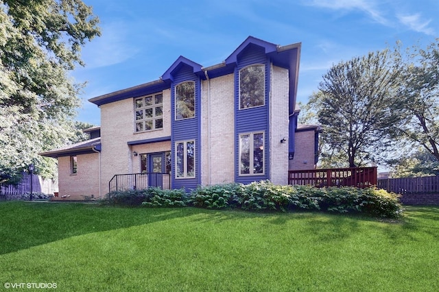 exterior space with fence, a front lawn, and brick siding