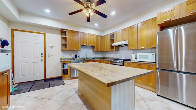 kitchen featuring light tile patterned floors, stainless steel appliances, open shelves, butcher block counters, and under cabinet range hood