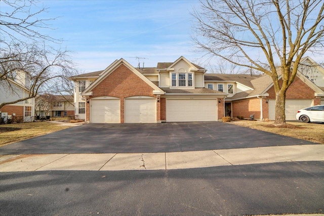 traditional-style house featuring a garage, brick siding, and driveway