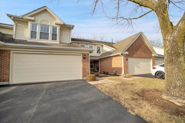 view of front of home featuring aphalt driveway, a garage, and brick siding