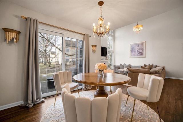 dining space featuring an inviting chandelier, baseboards, and wood finished floors