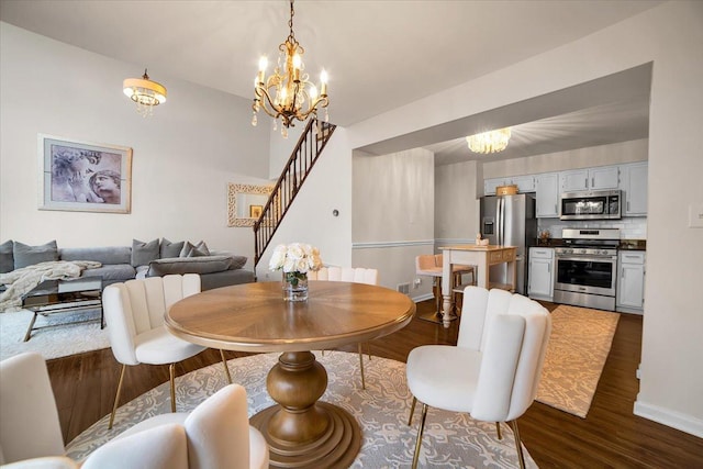 dining space featuring dark wood finished floors, an inviting chandelier, stairs, and baseboards