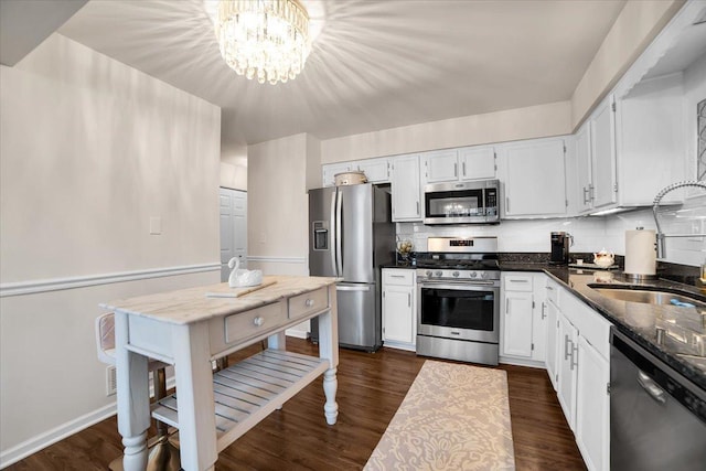 kitchen with dark wood finished floors, decorative backsplash, appliances with stainless steel finishes, and a sink