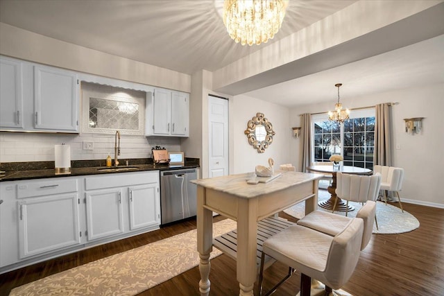 kitchen with dark wood-style floors, a sink, dishwasher, a notable chandelier, and tasteful backsplash