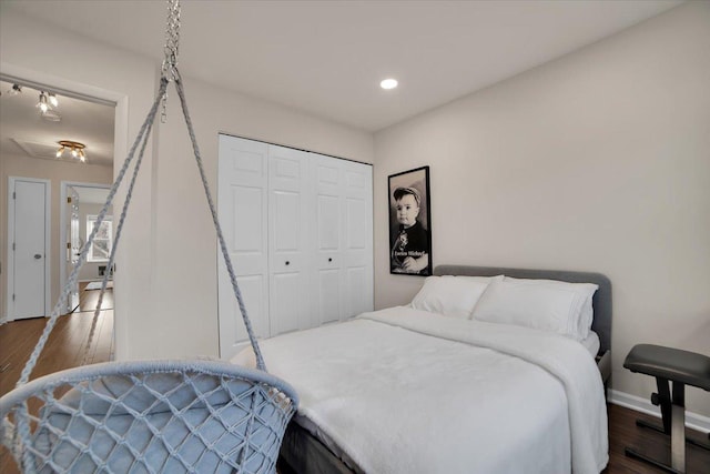 bedroom featuring a closet, recessed lighting, baseboards, and wood finished floors