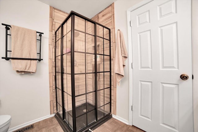 full bathroom featuring toilet, visible vents, a stall shower, and baseboards