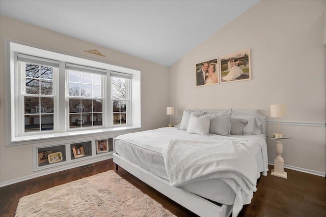 bedroom with lofted ceiling, wood finished floors, and baseboards