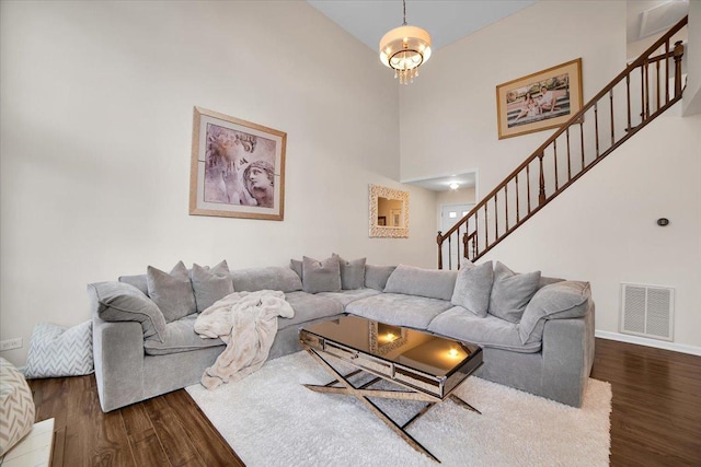 living area with visible vents, stairs, baseboards, and wood finished floors