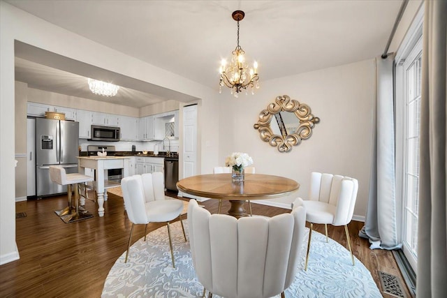 dining area with visible vents, baseboards, dark wood-type flooring, and an inviting chandelier