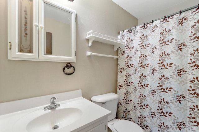 bathroom featuring toilet, a shower with shower curtain, and vanity