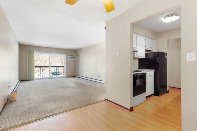 kitchen with light wood finished floors, white electric range oven, baseboard heating, an AC wall unit, and white cabinets