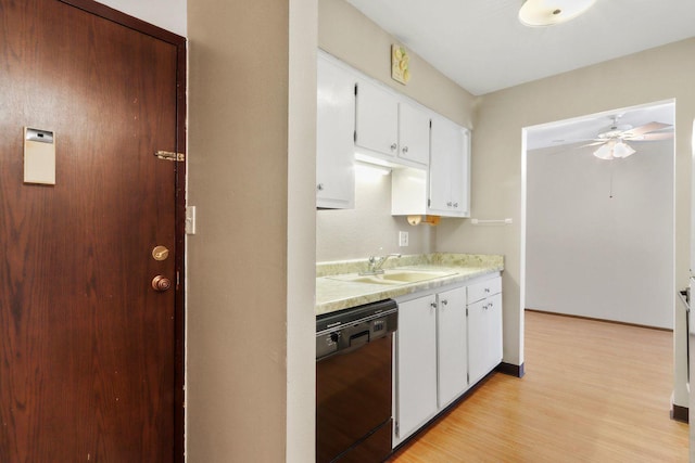 kitchen featuring light wood-style flooring, a sink, white cabinetry, black dishwasher, and light countertops