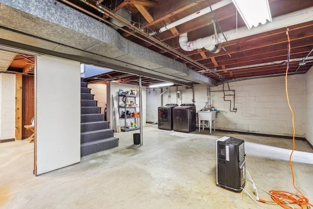 unfinished below grade area featuring stairway, washing machine and dryer, and a sink