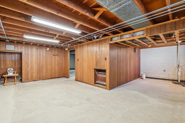 unfinished basement featuring concrete block wall