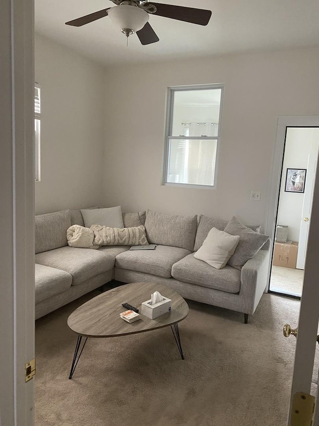 living area featuring carpet flooring and a ceiling fan