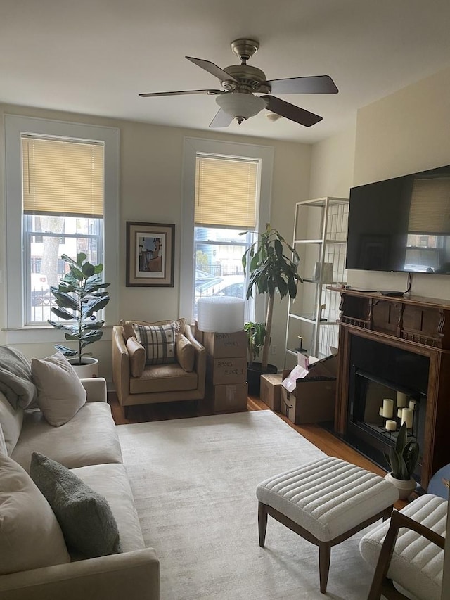 living area featuring a ceiling fan and a fireplace