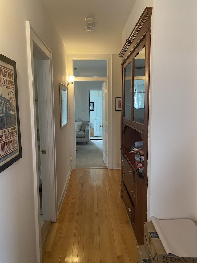 hallway with light wood finished floors and baseboards