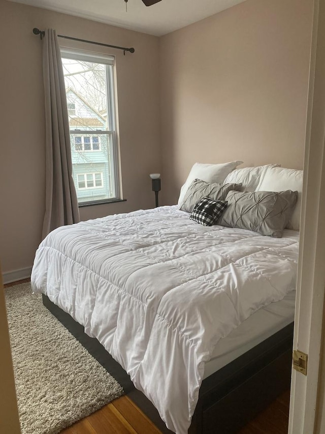 bedroom with wood finished floors and baseboards