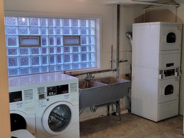 community laundry room featuring a sink, stacked washer and clothes dryer, and washing machine and clothes dryer