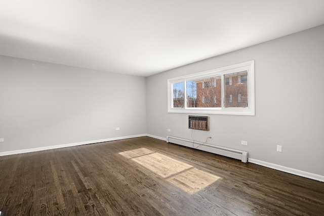 unfurnished room with a baseboard heating unit, baseboards, dark wood finished floors, and a wall mounted AC