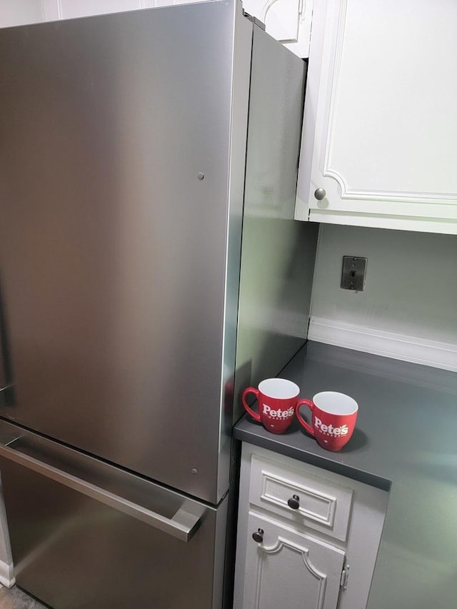 room details featuring dark countertops, white cabinetry, and freestanding refrigerator