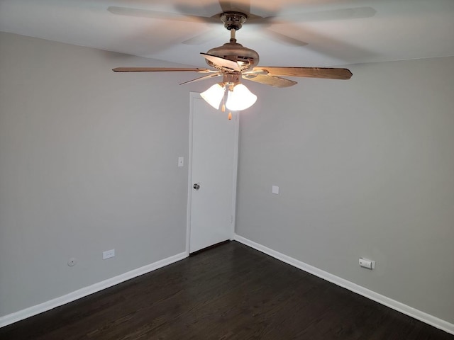 empty room with baseboards, dark wood finished floors, and a ceiling fan