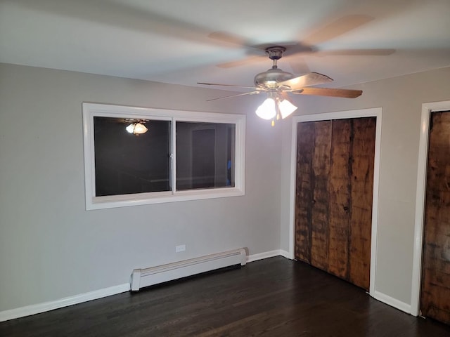 unfurnished bedroom featuring dark wood finished floors, ceiling fan, a baseboard heating unit, and baseboards