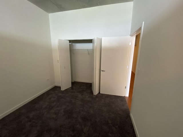 unfurnished bedroom featuring carpet floors, baseboards, and a closet