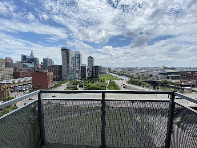 balcony featuring a water view and a city view