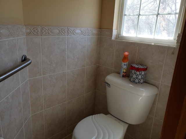 bathroom with toilet and tile walls