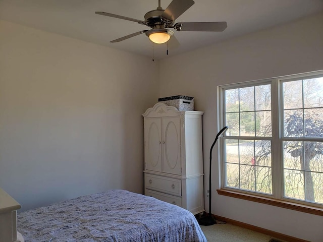 bedroom with baseboards, multiple windows, and a ceiling fan