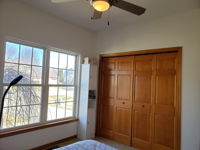 bedroom with a closet, multiple windows, and a ceiling fan